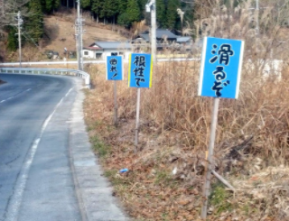 岐阜県恵那市にあった、 「根性で」「曲れ！」という看板。